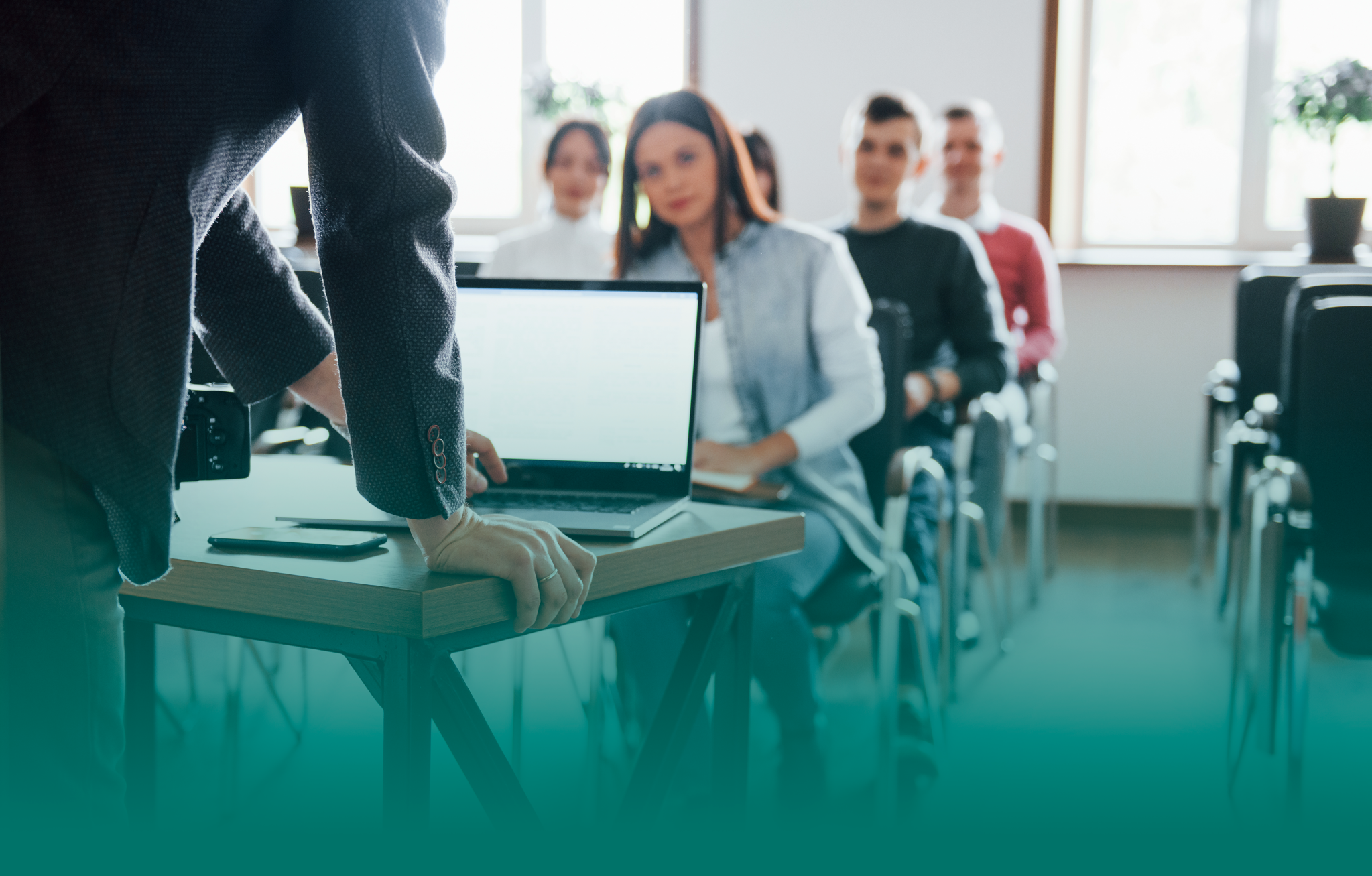 Persona mostrando su computador mientras una sala llena de personas observa
